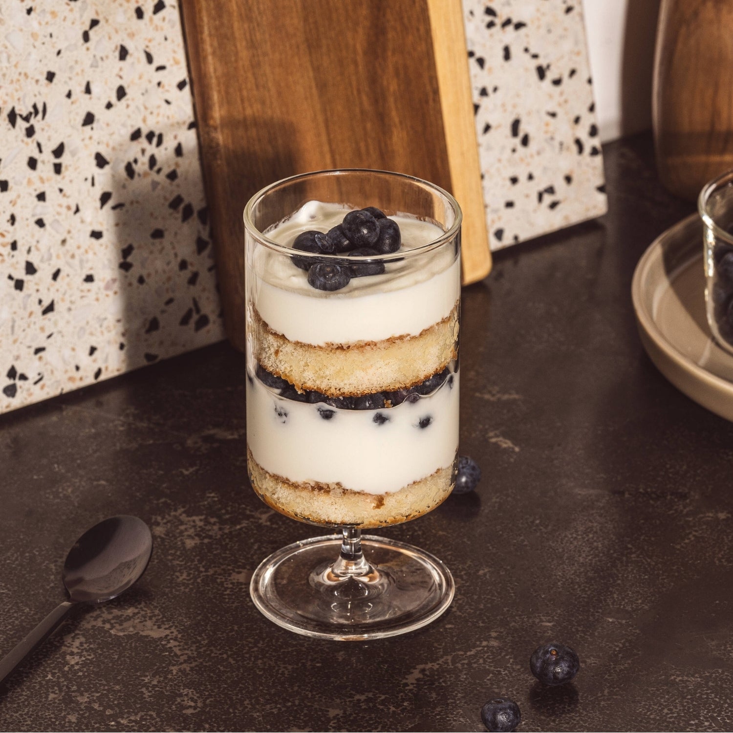 Schichtdessert mit Heidelbeeren angerichtet in einem BASSO Glas