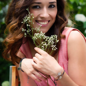 Junge Frau mit silbernem Armband MILA, hält Blumen, Außenaufnahme