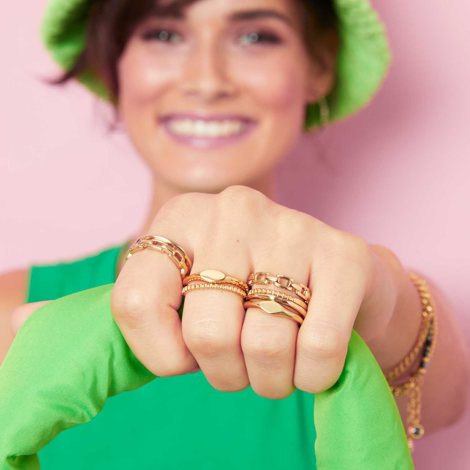 Ring ROCKY 17 CIAO in Gold an der Hand einer lächelnden Person getragen