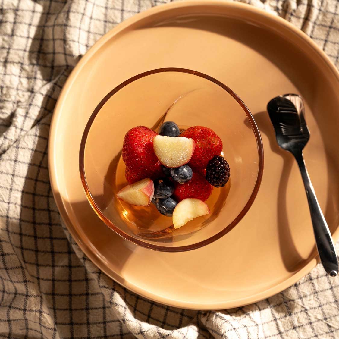Eisschale CONO mit frischen Beeren auf Leinentuch, Löffel daneben