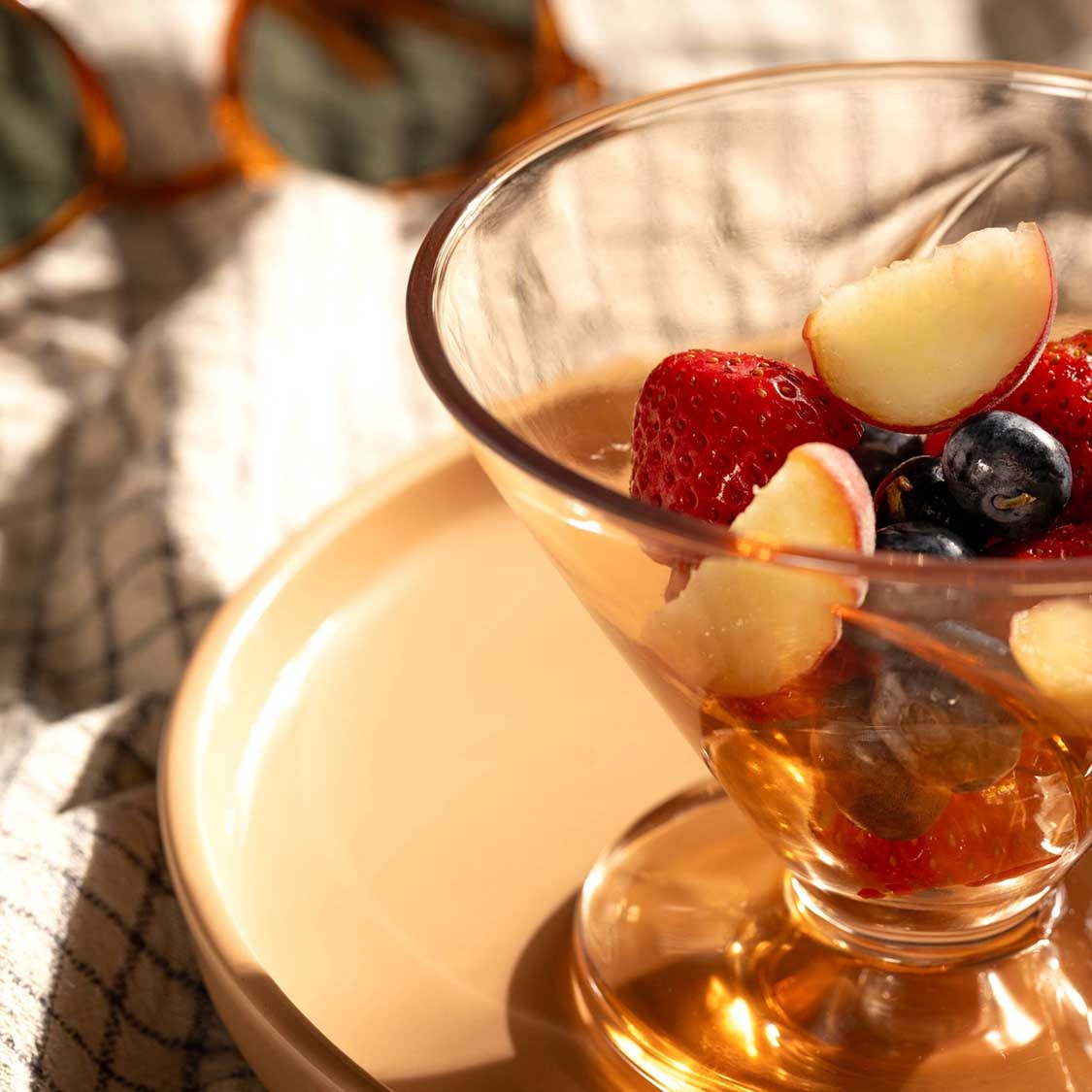 Eisschale CONO mit Früchten gefüllt, Sonnenlicht, Tisch mit Tuch