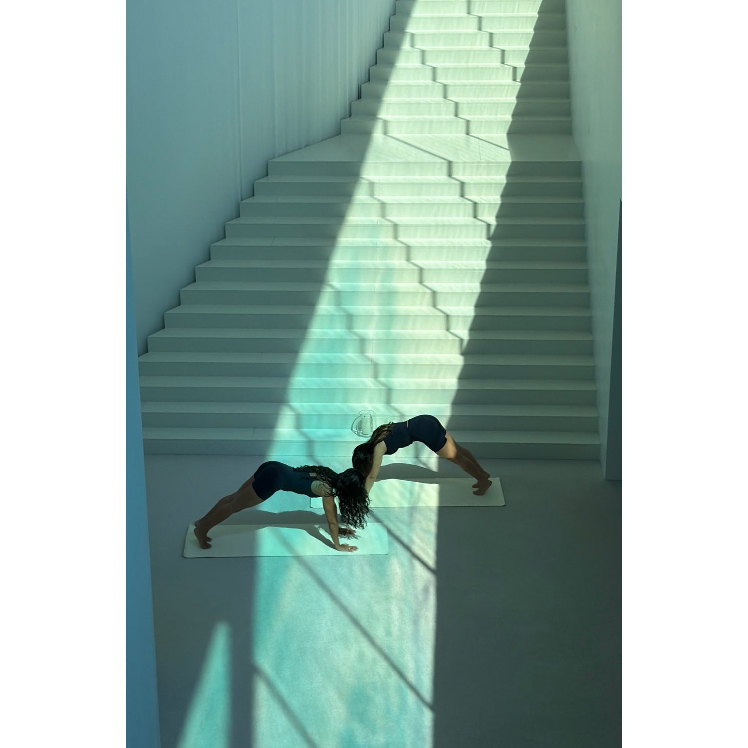 Person in Sportkleidung beim Pilates-Training auf Treppenstufen, Sonnenlicht