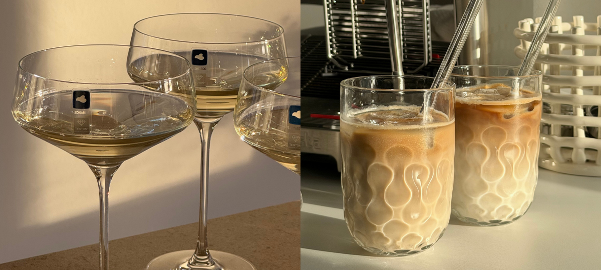 Mehrere Weißweingläser mit hellem Wein im warmen Sonnenlicht; daneben zwei Gläser mit Eiskaffee vor einer Kaffeemaschine.